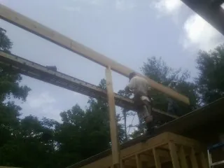 Carpenter setting a ridge beam over a new addition frame — Ice Dam Removal by Roofing Brothers in Mineral Ridge