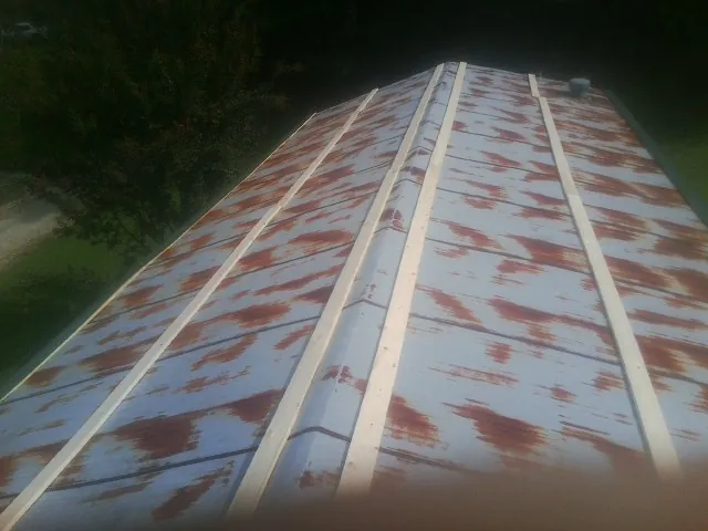 Rusted metal roof panels with new wood purlins before replacement — Storm Damage Roof Repair in Mineral Ridge by Roofing Brothers