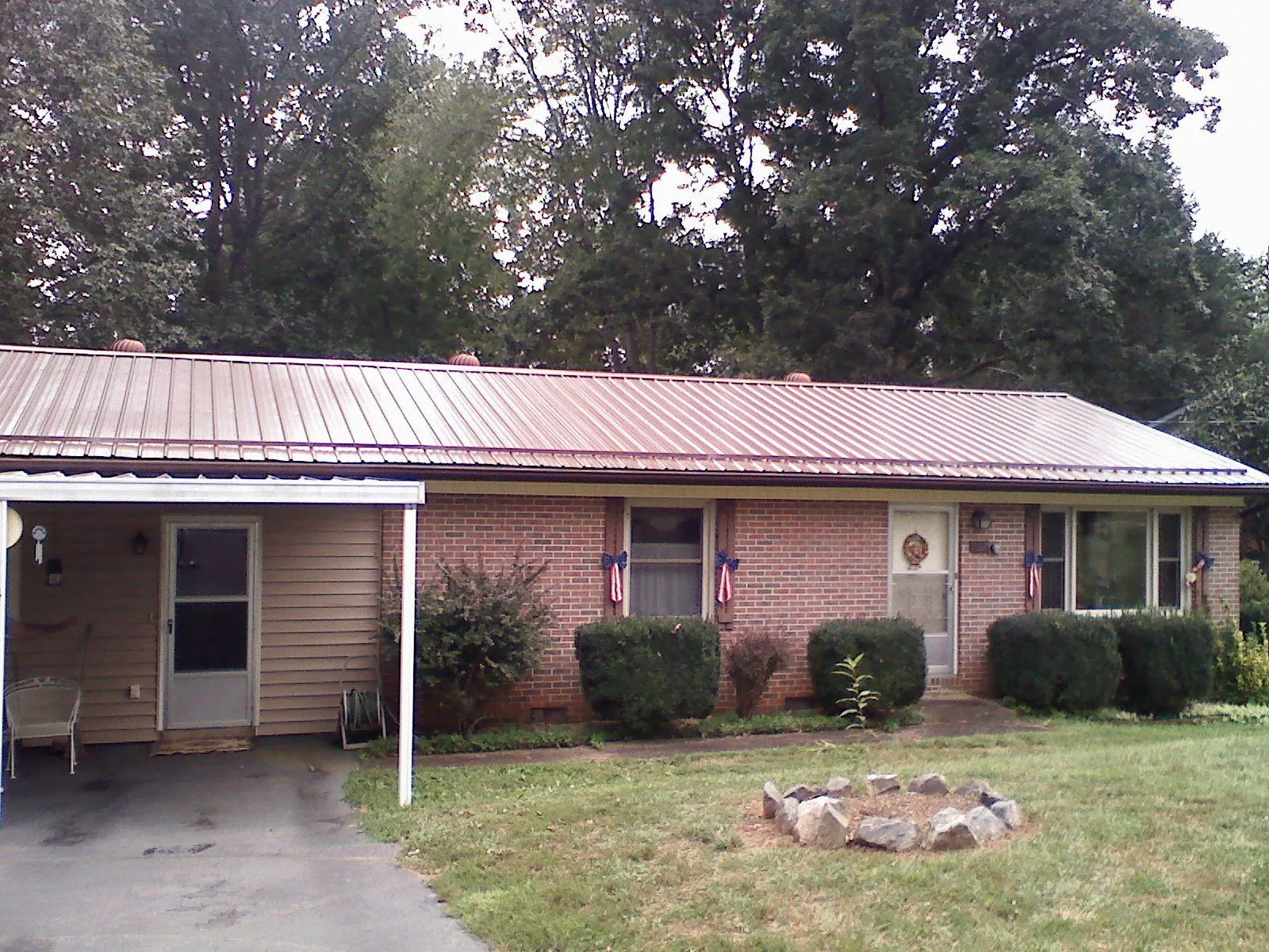 Bronze metal roof and carport on a brick ranch home — Roof Repair work by our crew in Mineral Ridge